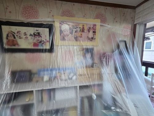 서초구 누수탐지 거실 벽면 하단 얼룩과 몰딩 들뜸을 점검하는 모습
