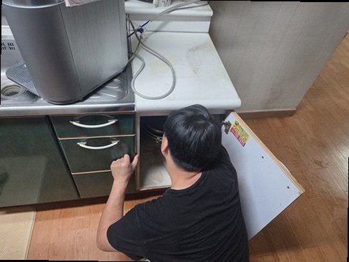 서대문구 누수탐지 싱크대 하부와 벽면의 누수 흔적을 확인하는 모습