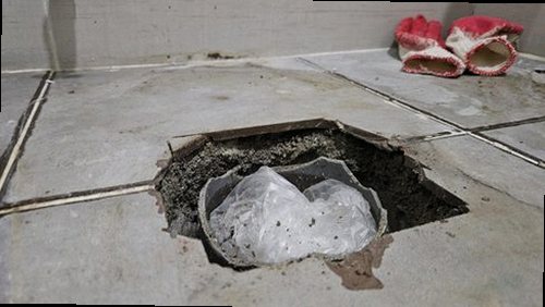 부평구 누수탐지 싱크대 하부장과 벽면의 누수 흔적을 점검하는 모습